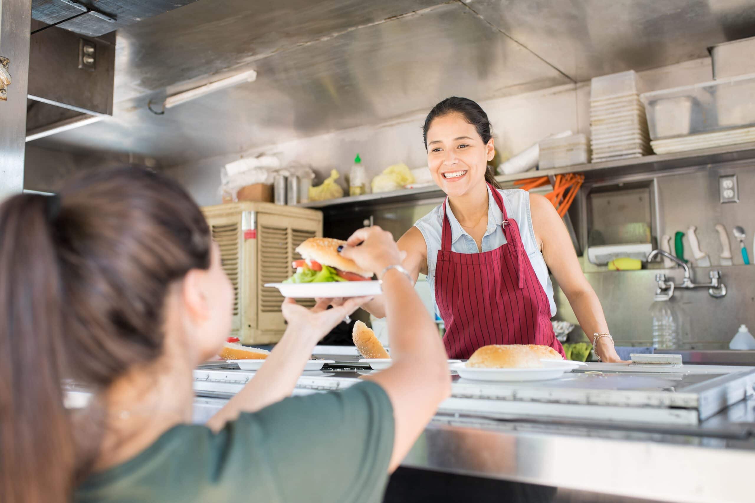 Happy woman selling hamburgers